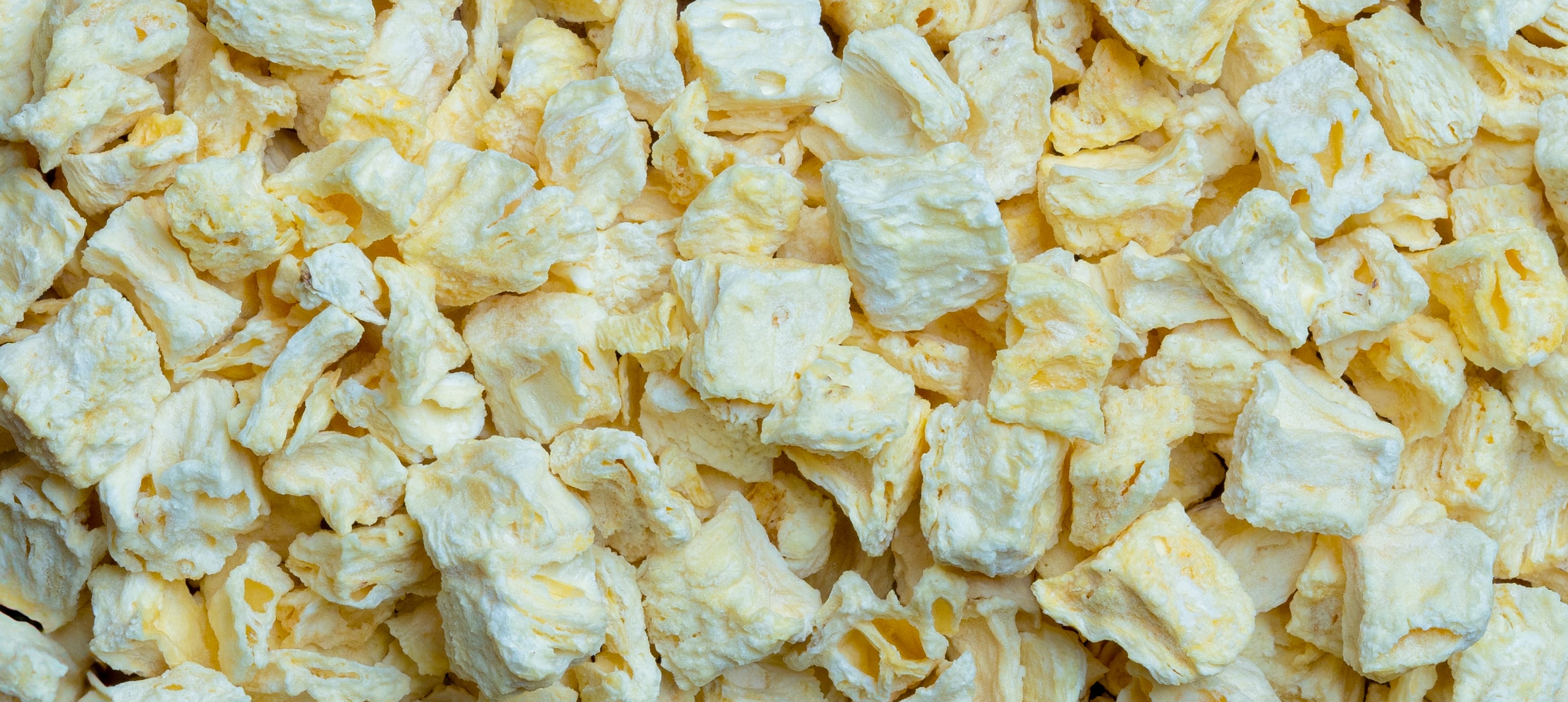 Frau mit gefriergetrockneter Ananas im Mund