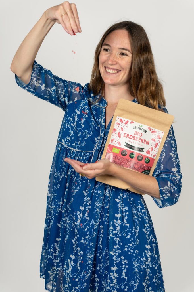 Kind sitzt in der Küche mit gefriergetrockneten Himbeeren