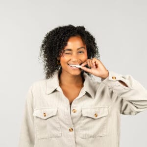 Frau vor einer weißen Wand mit gefriergetrockneten Früchten