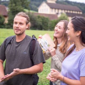 Ein Mann und zwei Frauen beim Wandern mit gefriergetrockneter Jackfruit Packung
