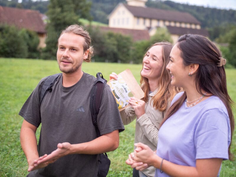 Ein Mann und zwei Frauen beim Wandern mit gefriergetrockneter Jackfruit Packung