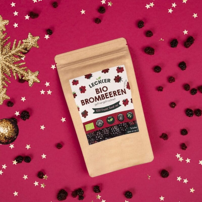 leckkers gefriergetrocknete Brombeeren liegen neben Deko
