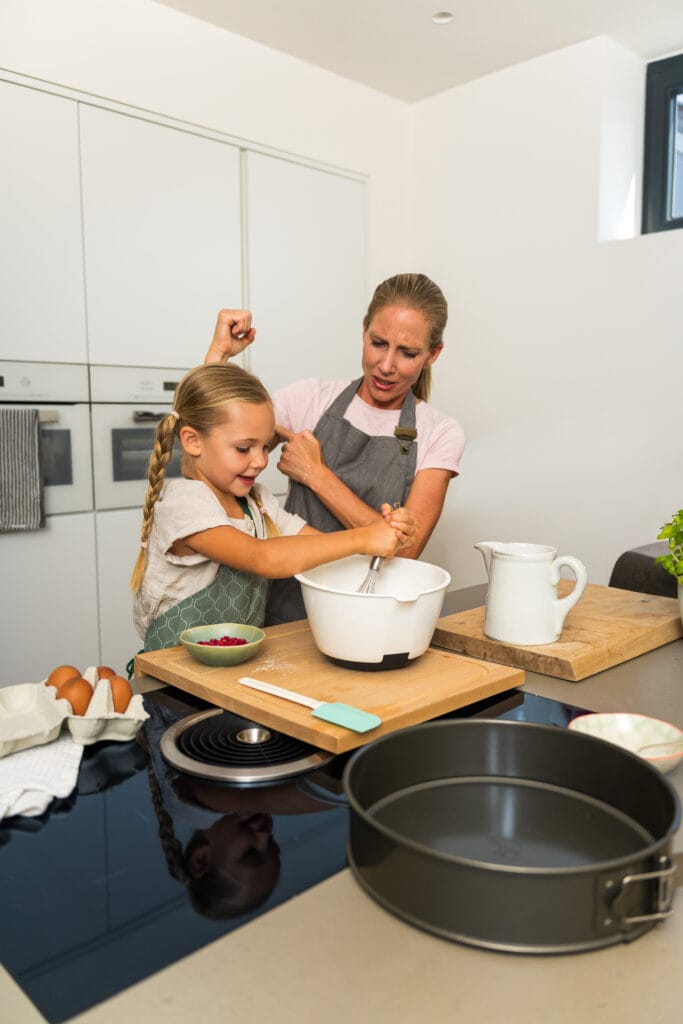 Kind sitzt in der Küche mit gefriergetrockneten Himbeeren