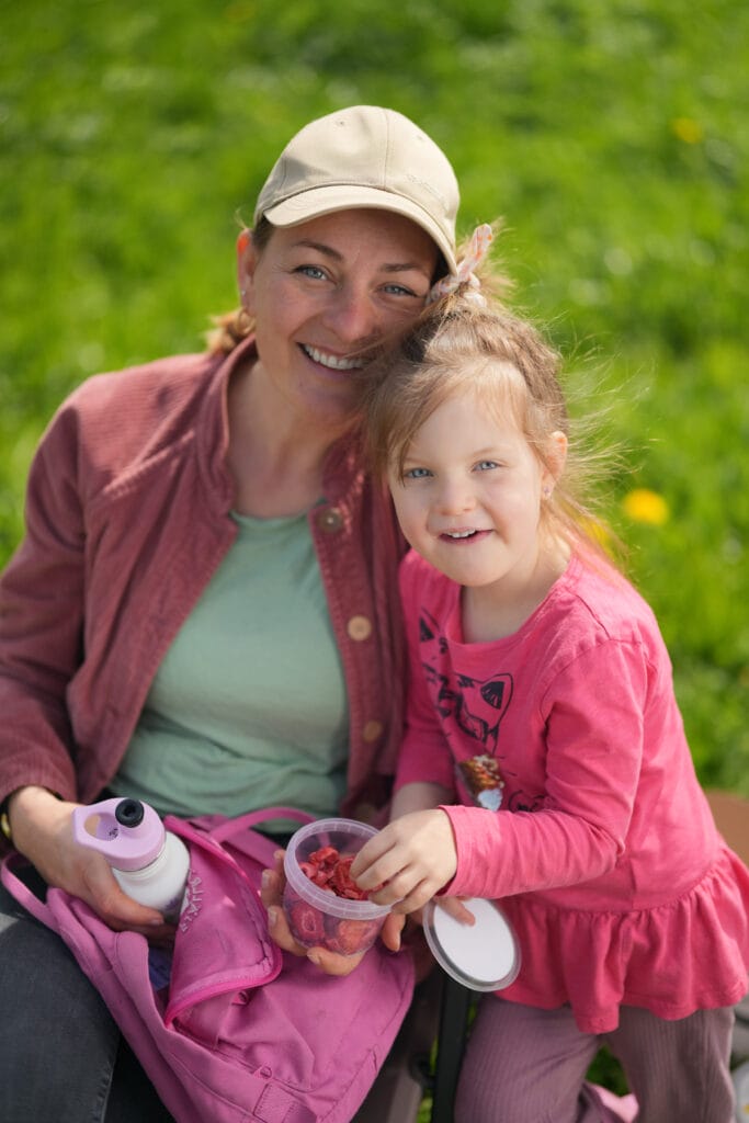 Kind sitzt in der Küche mit gefriergetrockneten Himbeeren